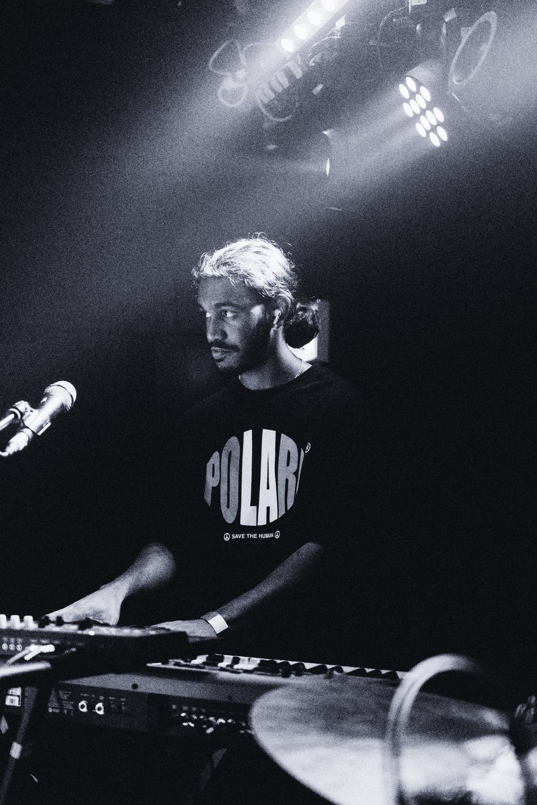 Keys player lit from above in black and white, head turned to the side