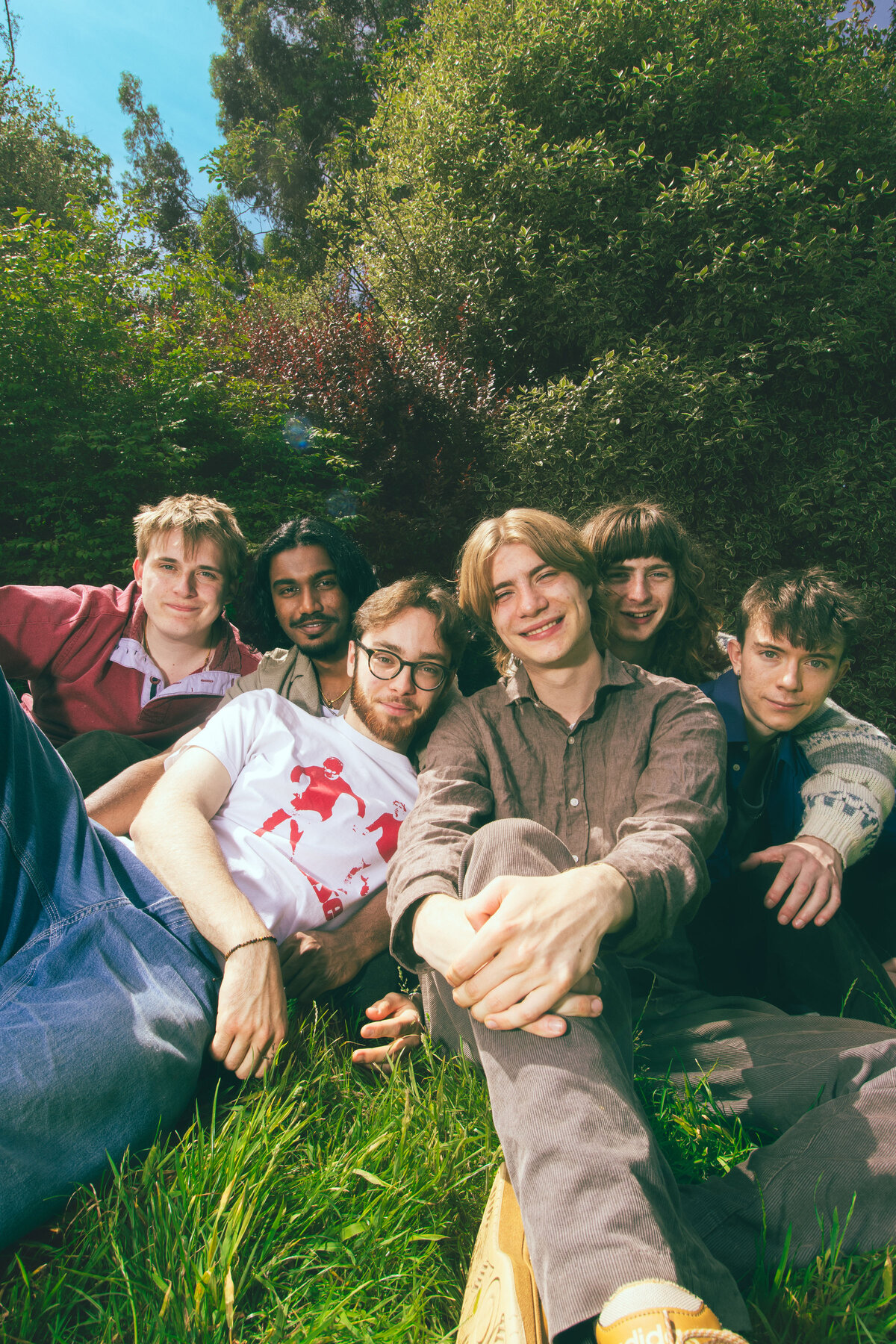 Happy Garden group promo photo, sitting outdoors on grass